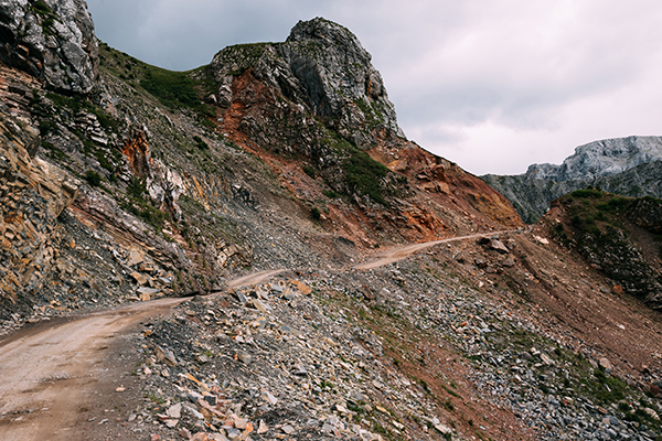 Mountain top dirt road with no cars representing the high road